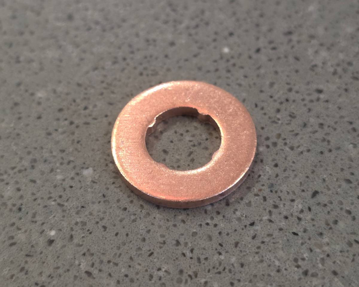 Copper washer on a gray concrete surface