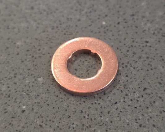 Copper washer on a gray concrete surface