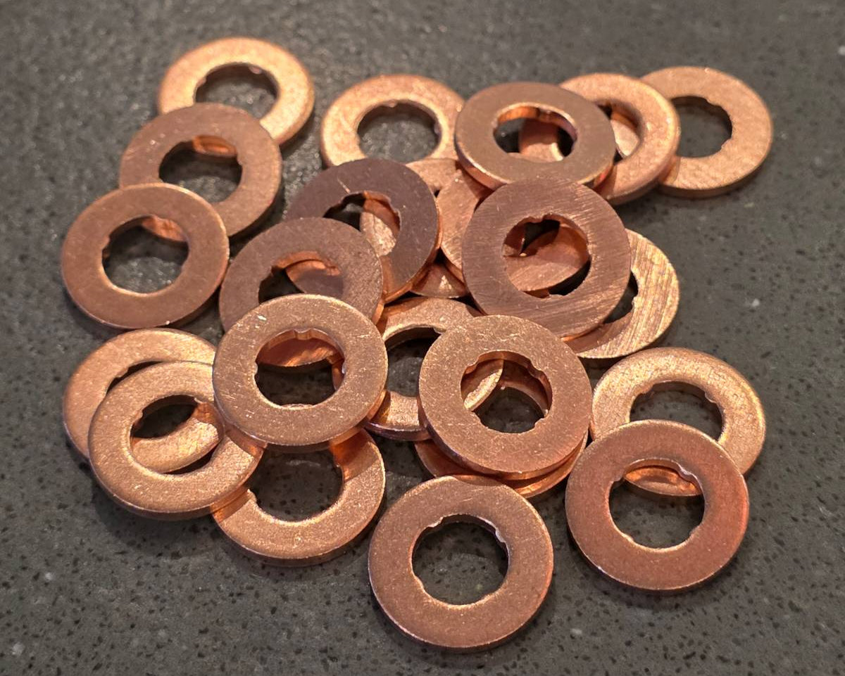 Collection of copper washers on a dark surface